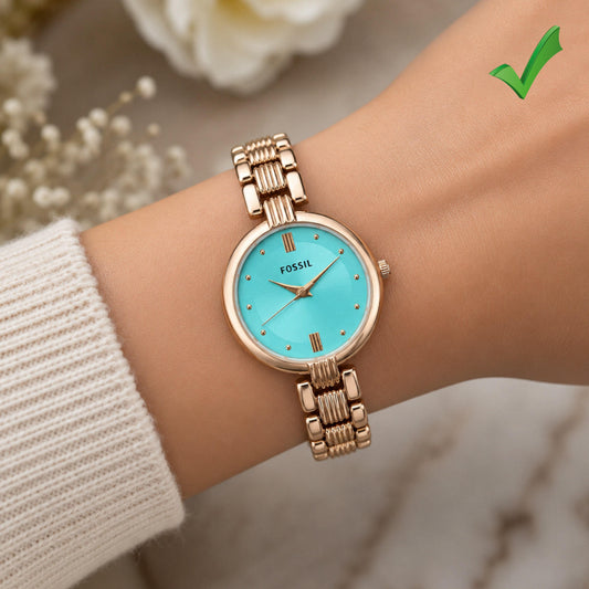 Women's rose-gold tone watch with turquoise dial and bracelet on wrist