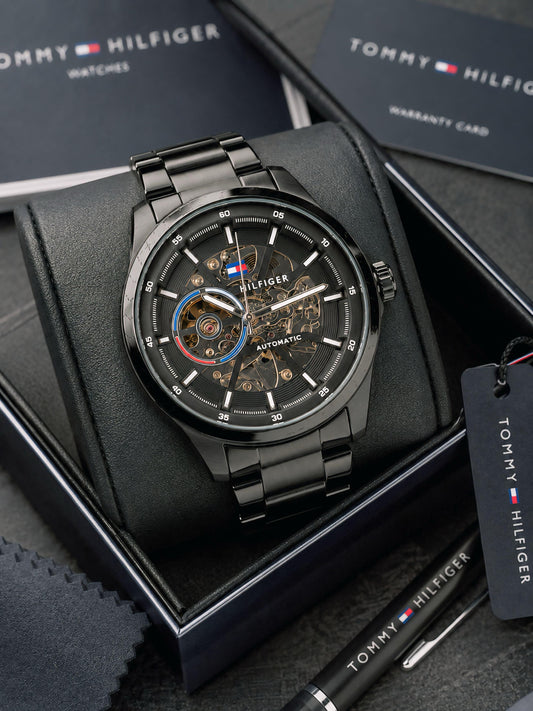 Automatic skeleton watch close-up: black case, open-work dial with visible gears and markers