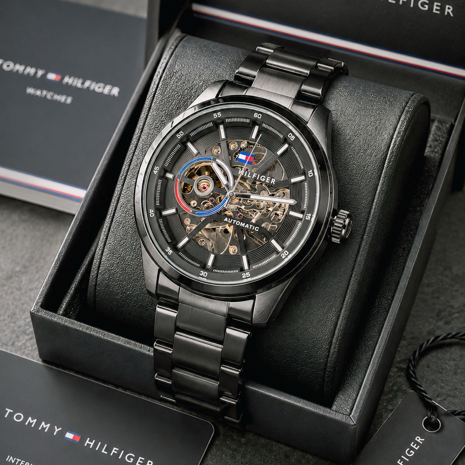 Automatic skeleton watch with black metal bracelet, round case, and exposed mechanical dial