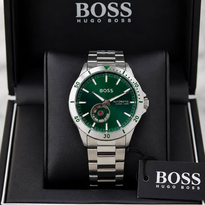 A Hugo Boss automatic watch with a green dial and silver stainless steel case and bracelet, presented inside an open black Hugo Boss gift box with a branded hangtag.