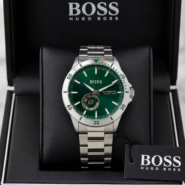 A Hugo Boss automatic watch with a green dial and silver stainless steel case and bracelet, presented inside an open black Hugo Boss gift box with a branded hangtag.