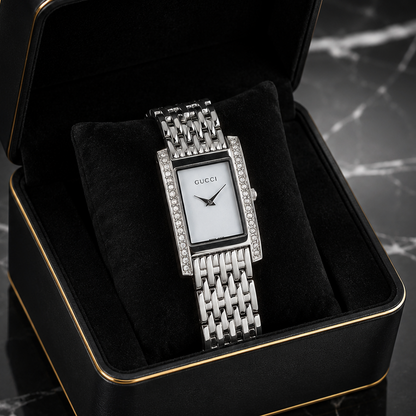 Elegant silver rectangular women's watch with a mother-of-pearl style dial, crystal-studded bezel, and stainless steel bracelet.