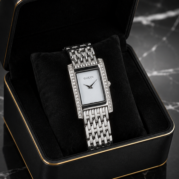 Elegant silver rectangular women's watch with a mother-of-pearl style dial, crystal-studded bezel, and stainless steel bracelet.
