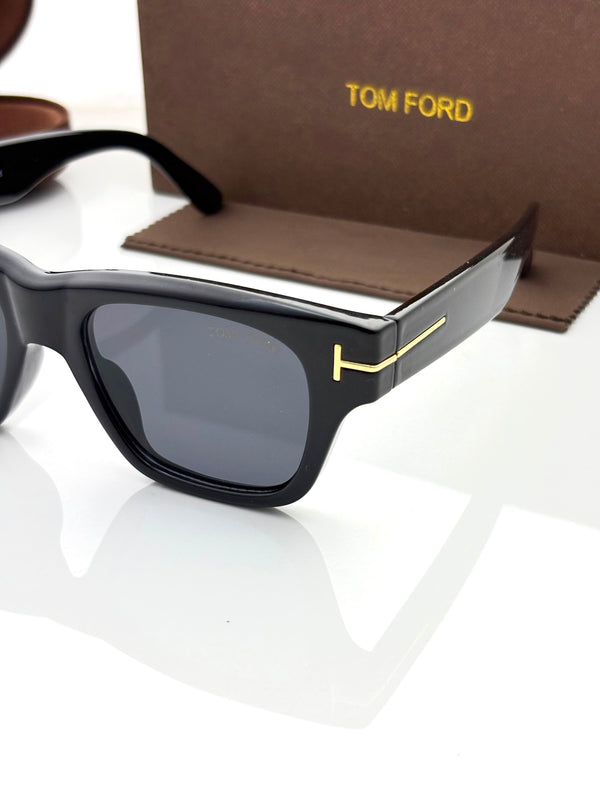 Black square sunglasses with dark lenses and gold logo accents, with brown case