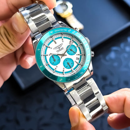 Silver and blue watch held by a hand with a blurred background