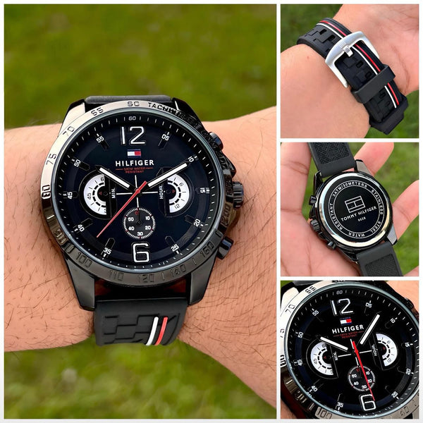 Men's black chronograph watch on wrist, black silicone strap with red stripe, detailed subdials